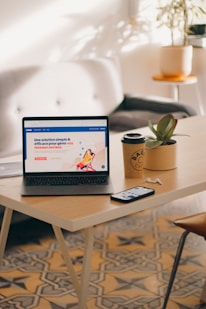 a laptop computer sitting on top of a wooden table