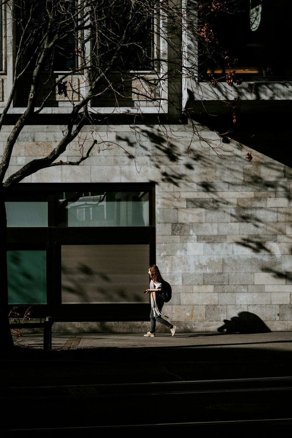 a person walking down a sidewalk next to a building