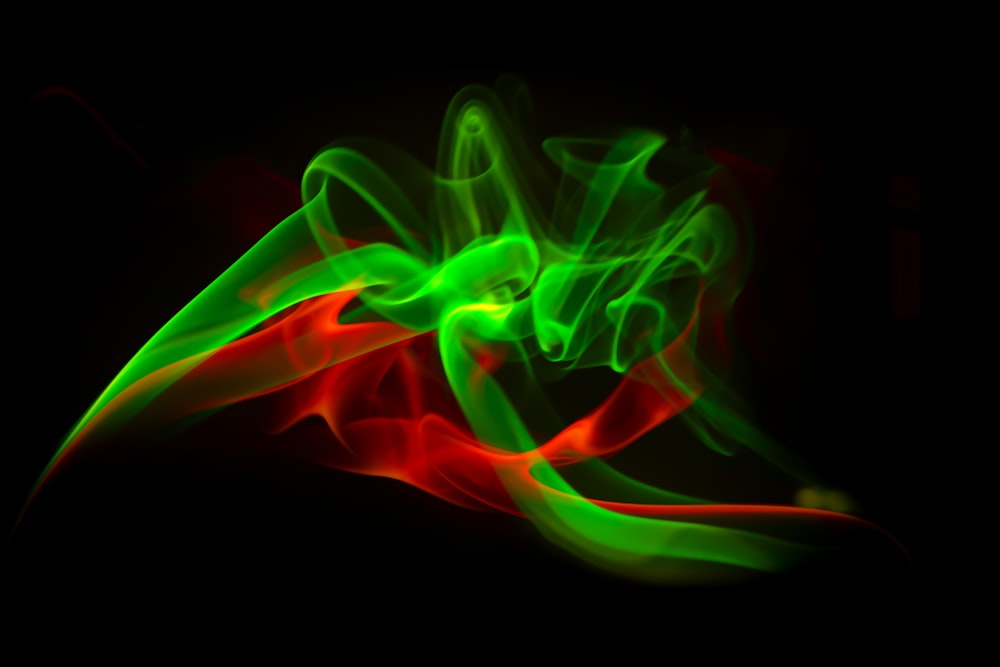 a green and red smoke is in the dark