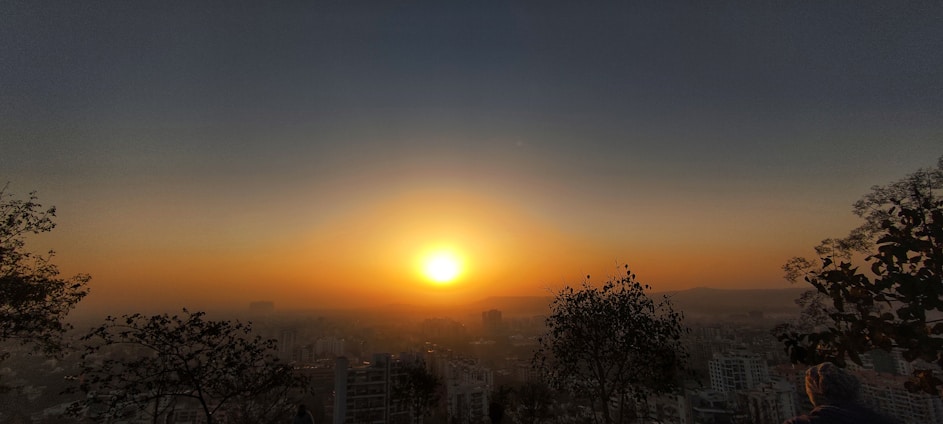 A panoramic view of Jaipur city highlighting prime plot locations with a warm sunset glow.