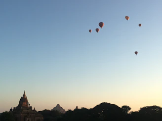 A serene hot air balloon gently ascending over Luxor’s temples under a clear morning sky.