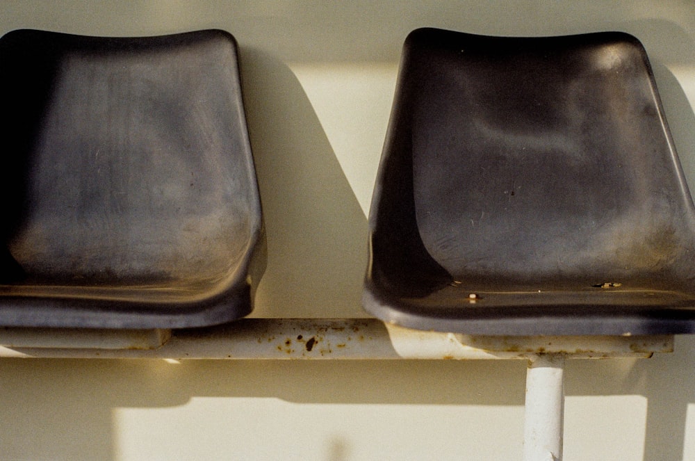 a couple of seats sitting on top of a metal bench