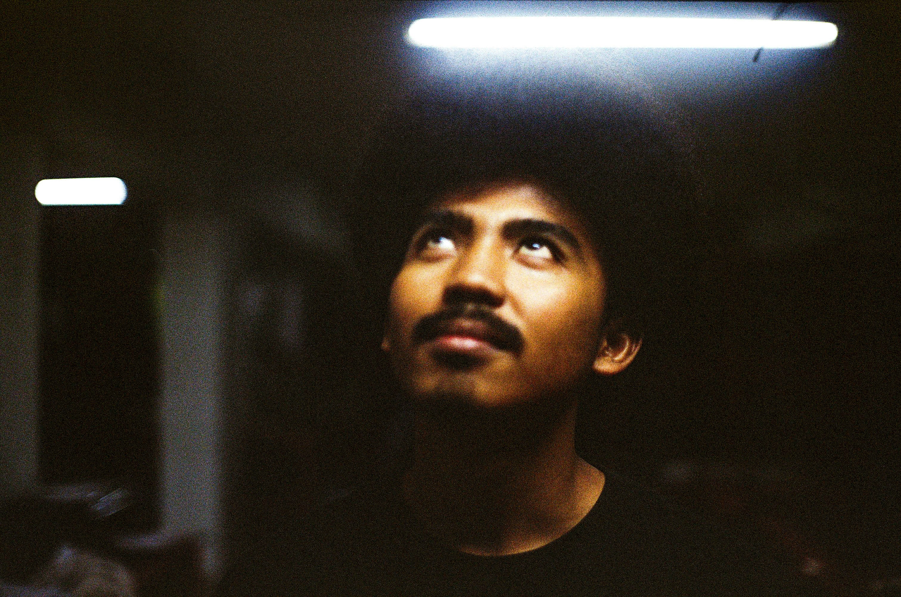 a man with a mustache looking up at something