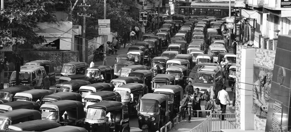a black and white photo of a street filled with cars