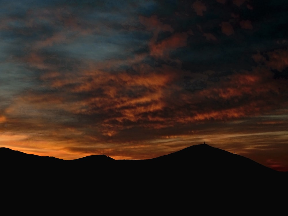 the sun is setting over a mountain range