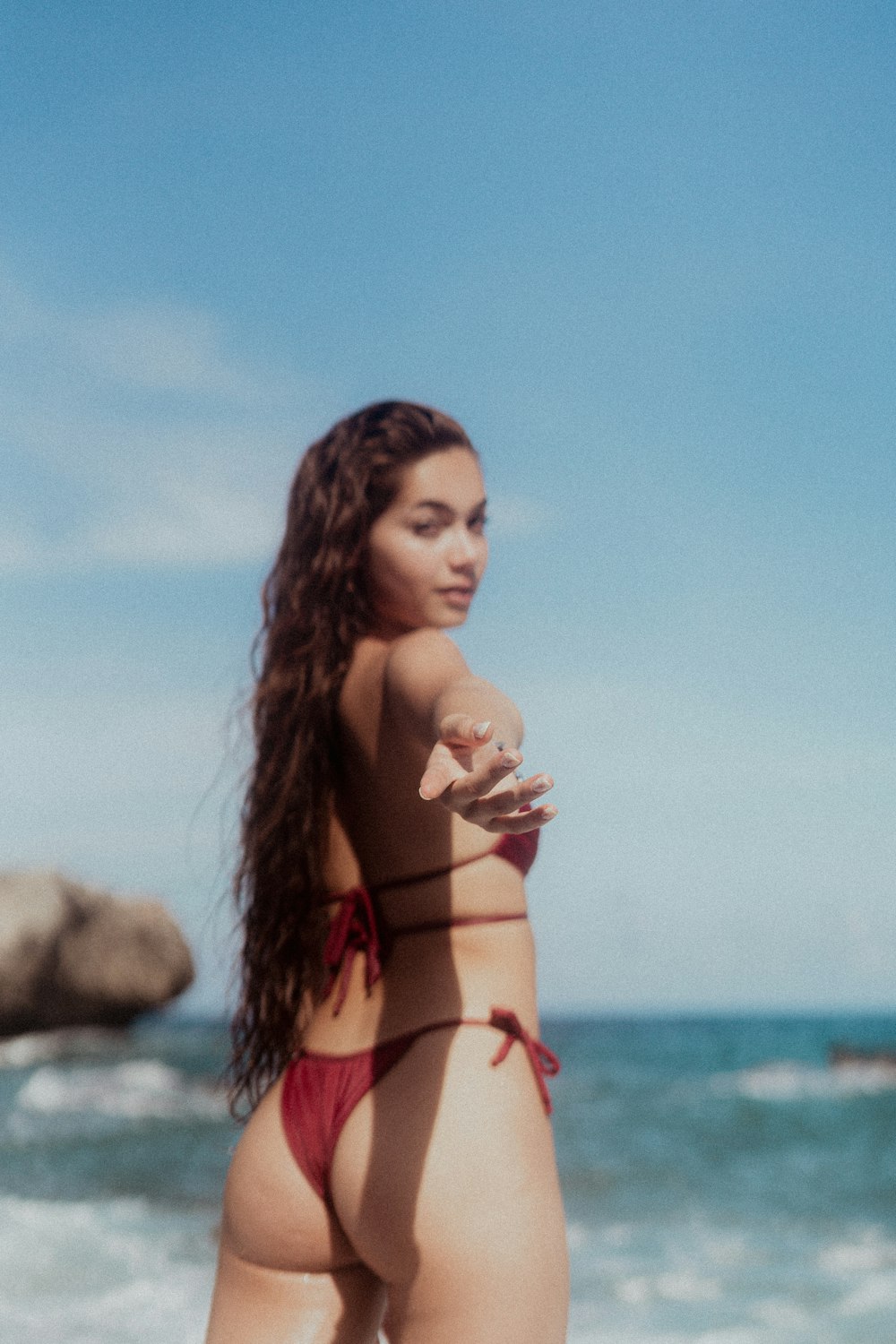 a woman in a bikini standing on the beach