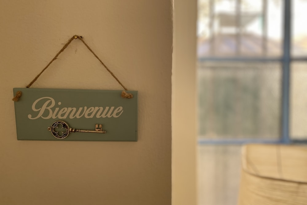 a blue sign hanging on a wall next to a window