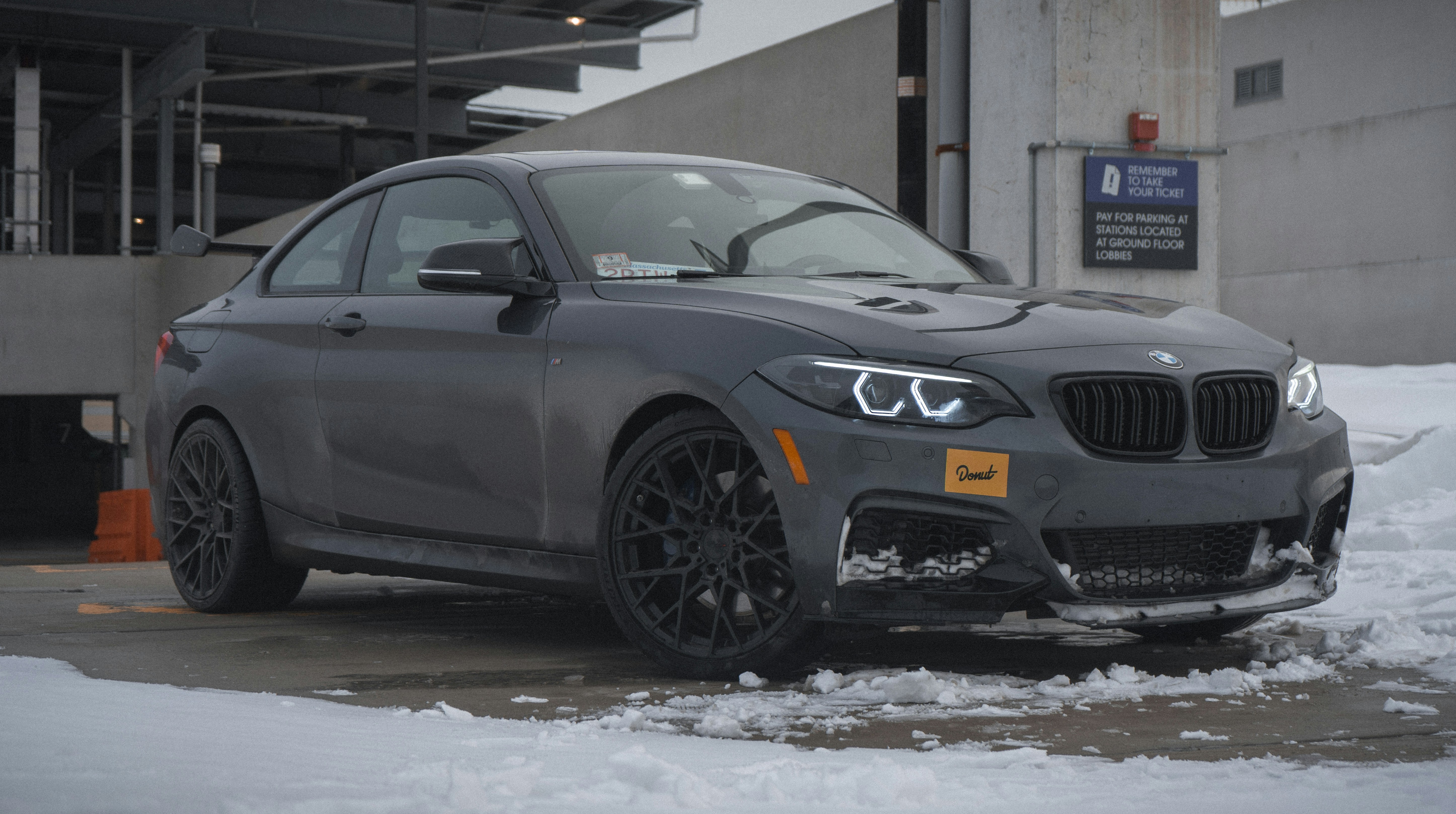 a grey car parked in a parking lot covered in snow