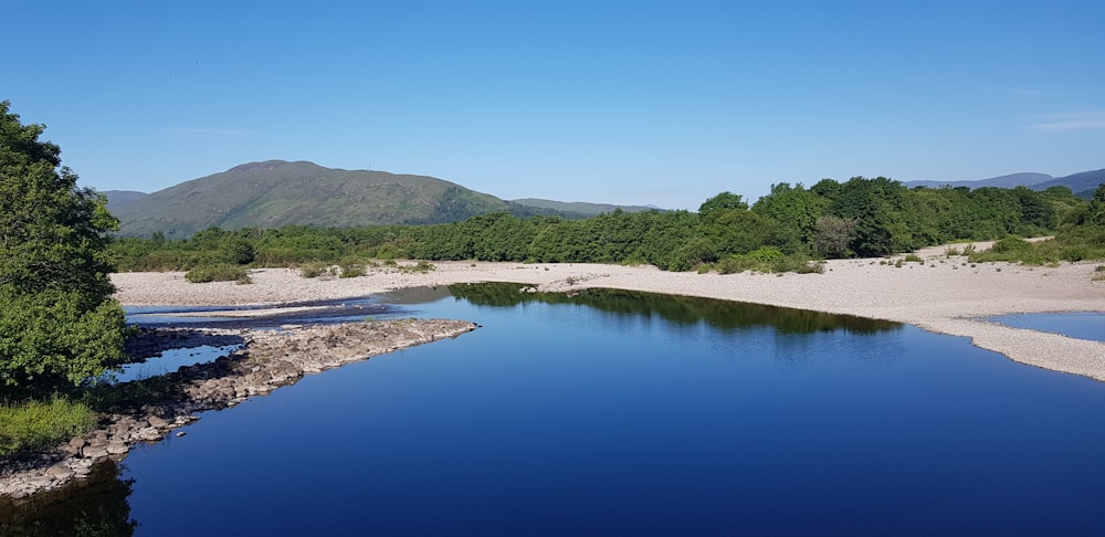 a body of water surrounded by trees and mountains