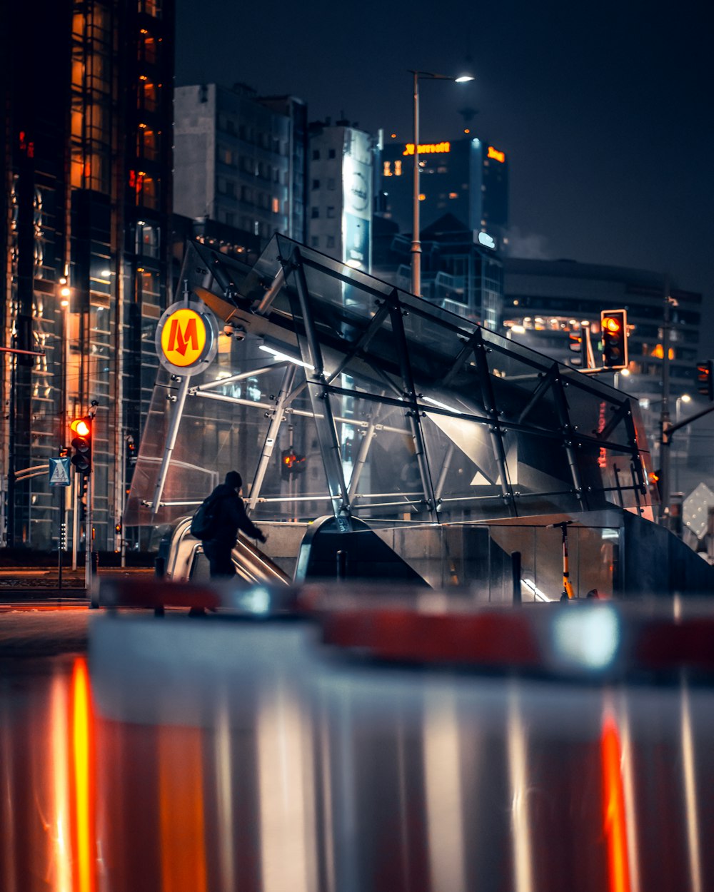 a city at night with a person on an escalator