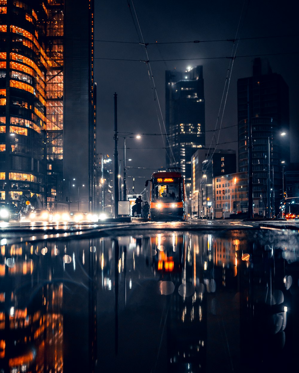 a city at night with a train on the tracks