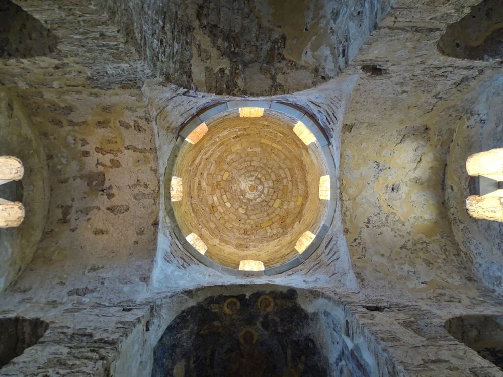 the ceiling of a stone building with a circular window