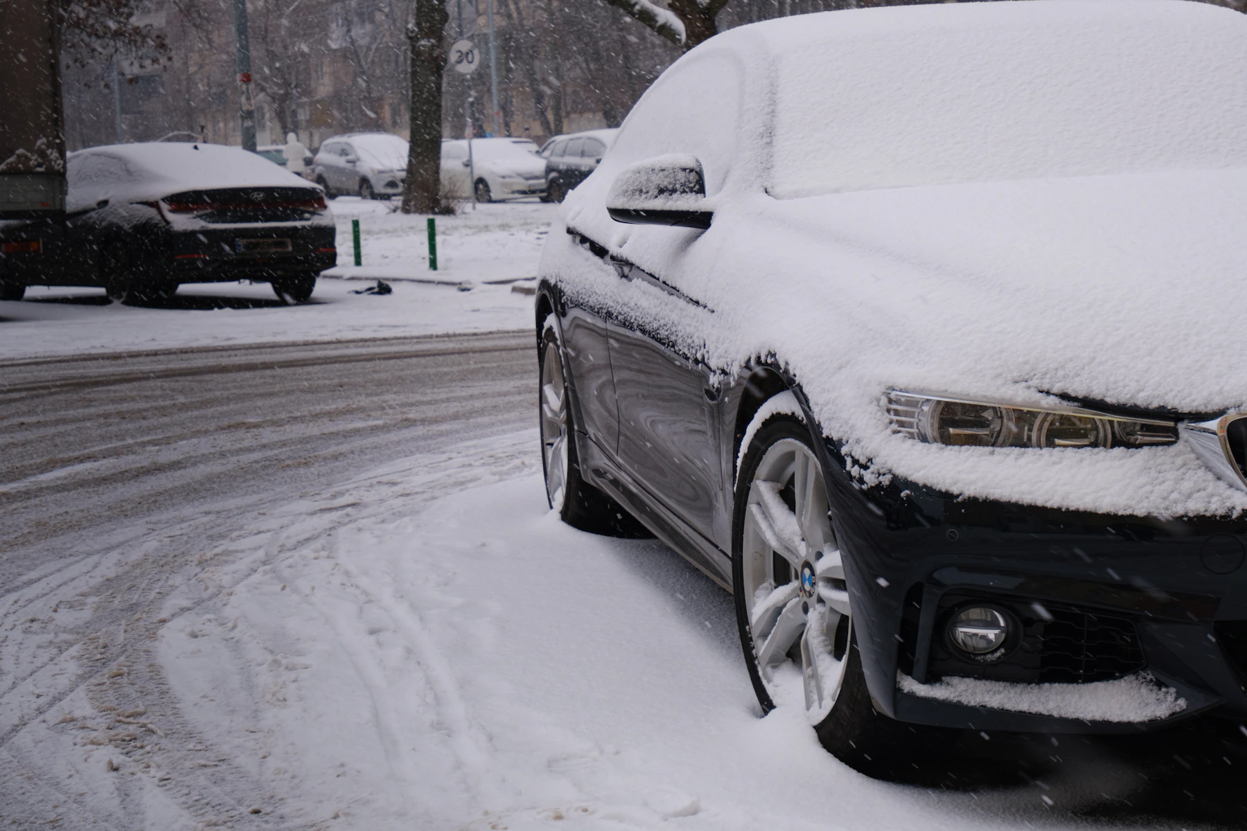 Verschneites Auto, Rad im Schnee