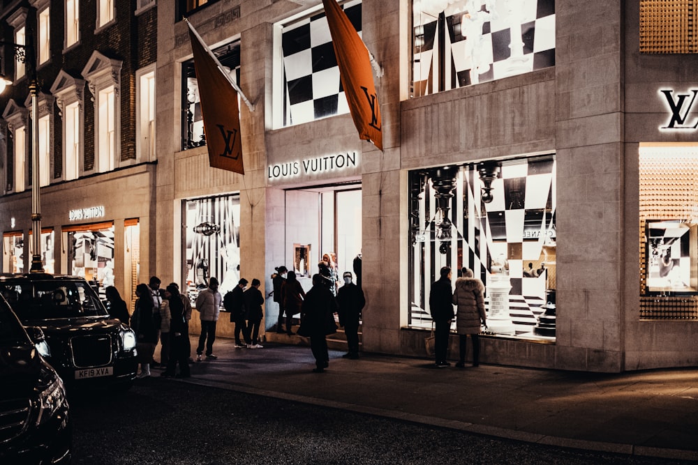 Foto Un grupo de personas de pie fuera de una tienda Louis Vuitton – Imagen  Humano gratis en Unsplash