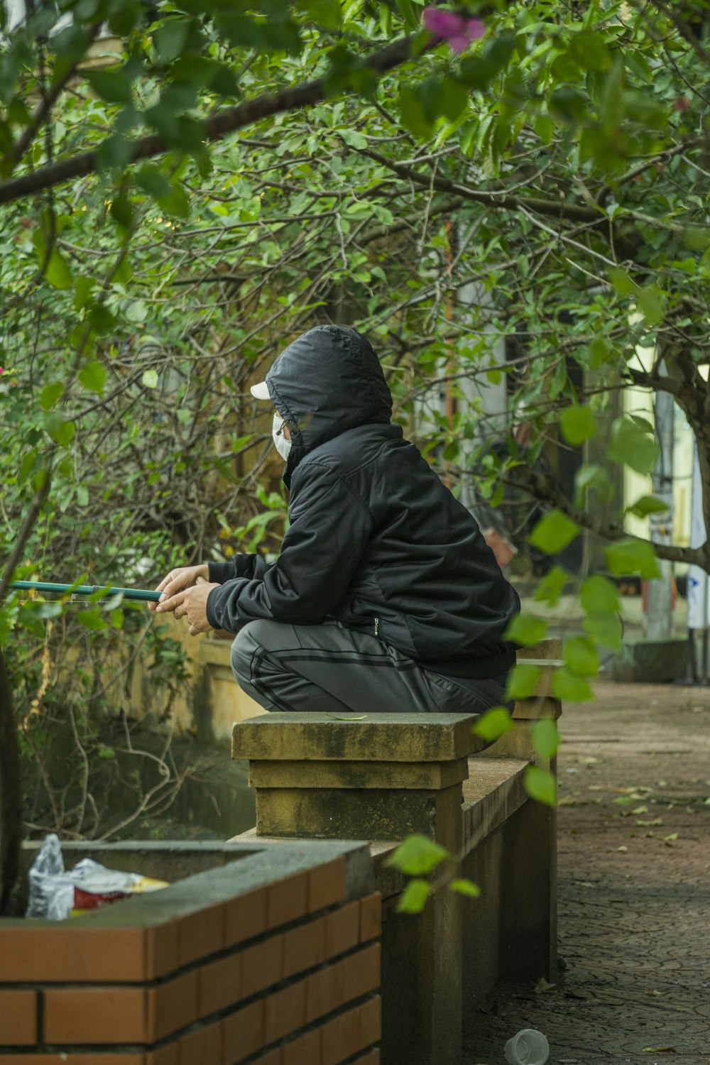 a man in a black jacket is sitting on a bench