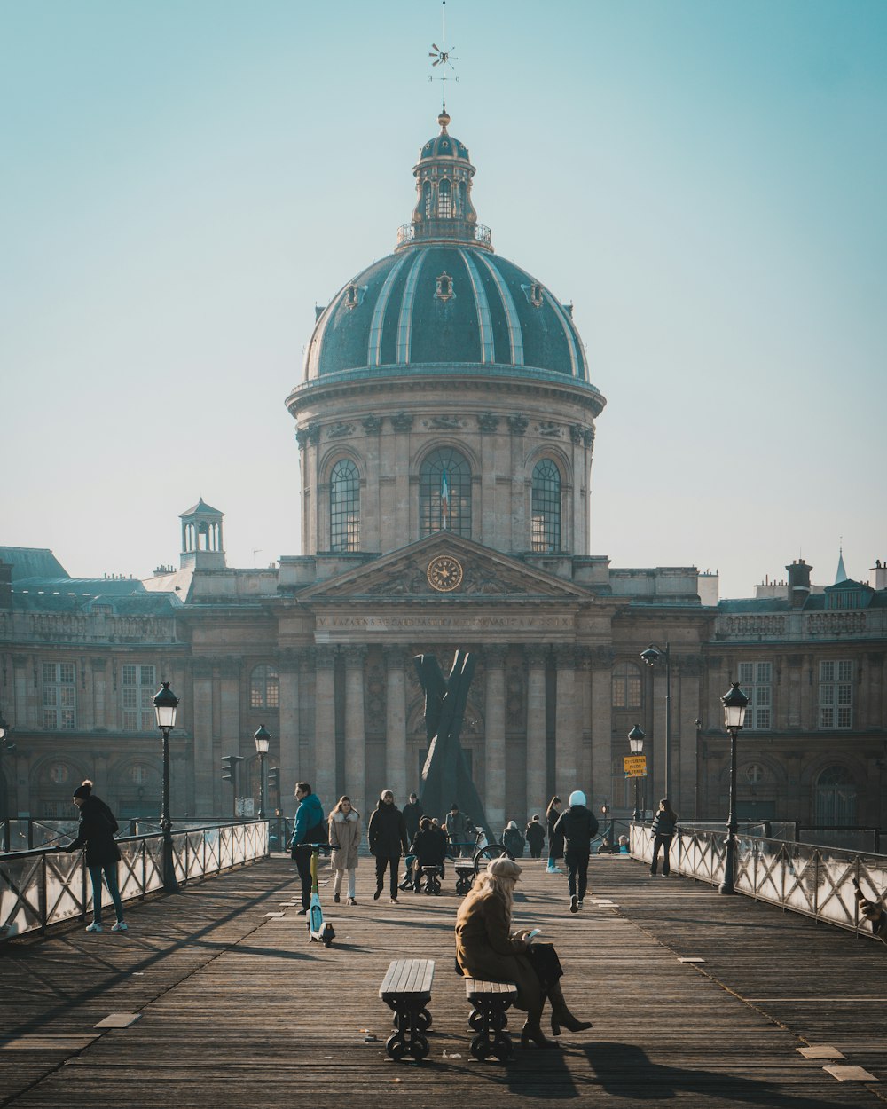 a woman sitting on a bench in front of a building