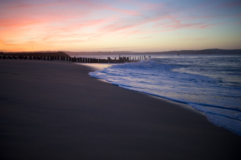 a beach that has some waves coming in to the shore