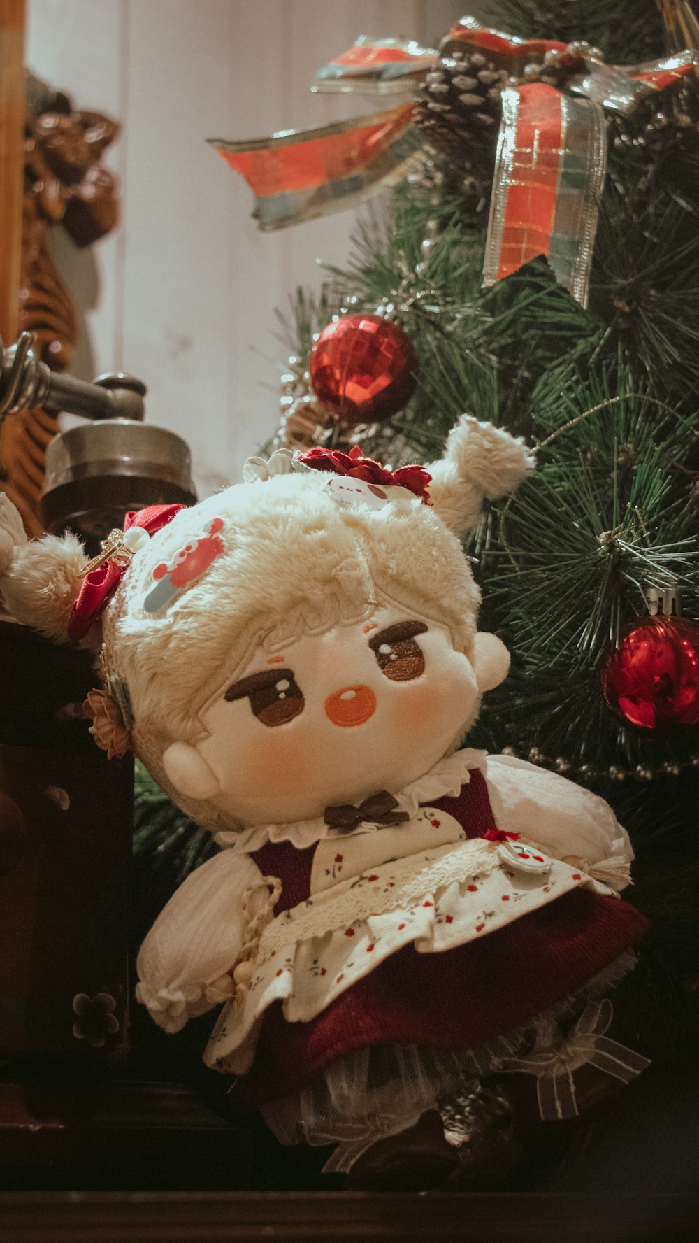 a teddy bear sitting next to a christmas tree