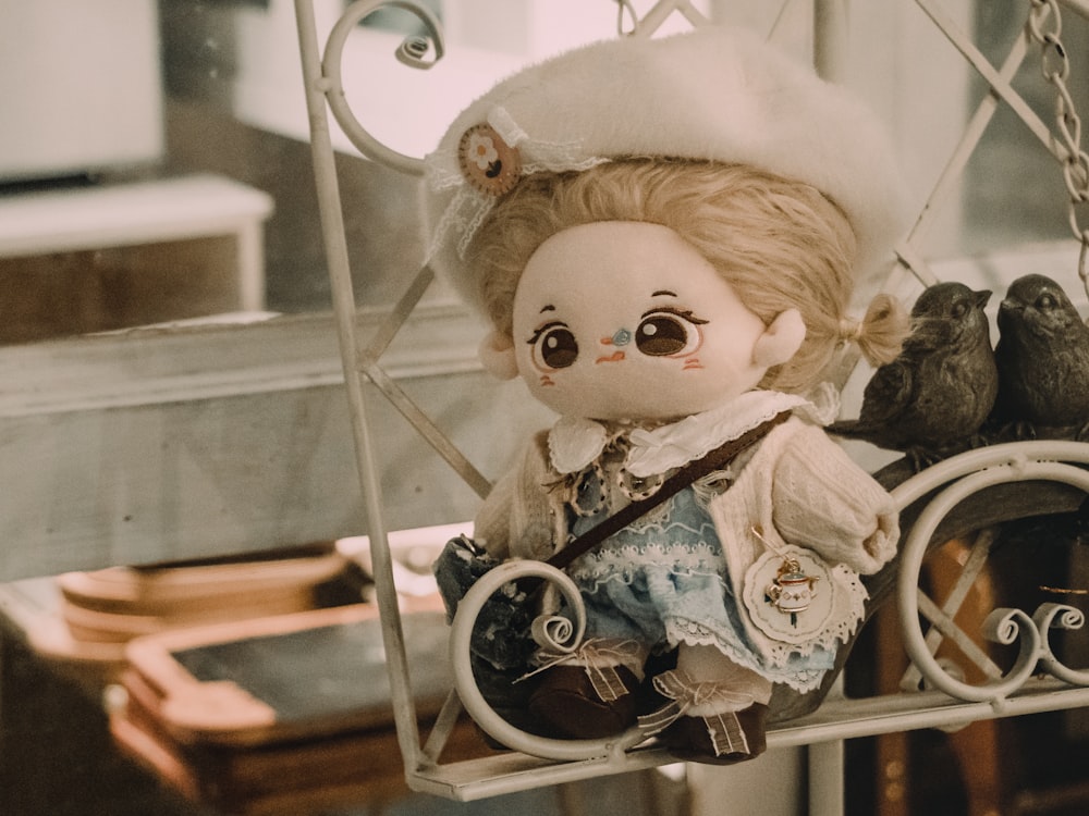 a doll with big eyes sitting on a swing