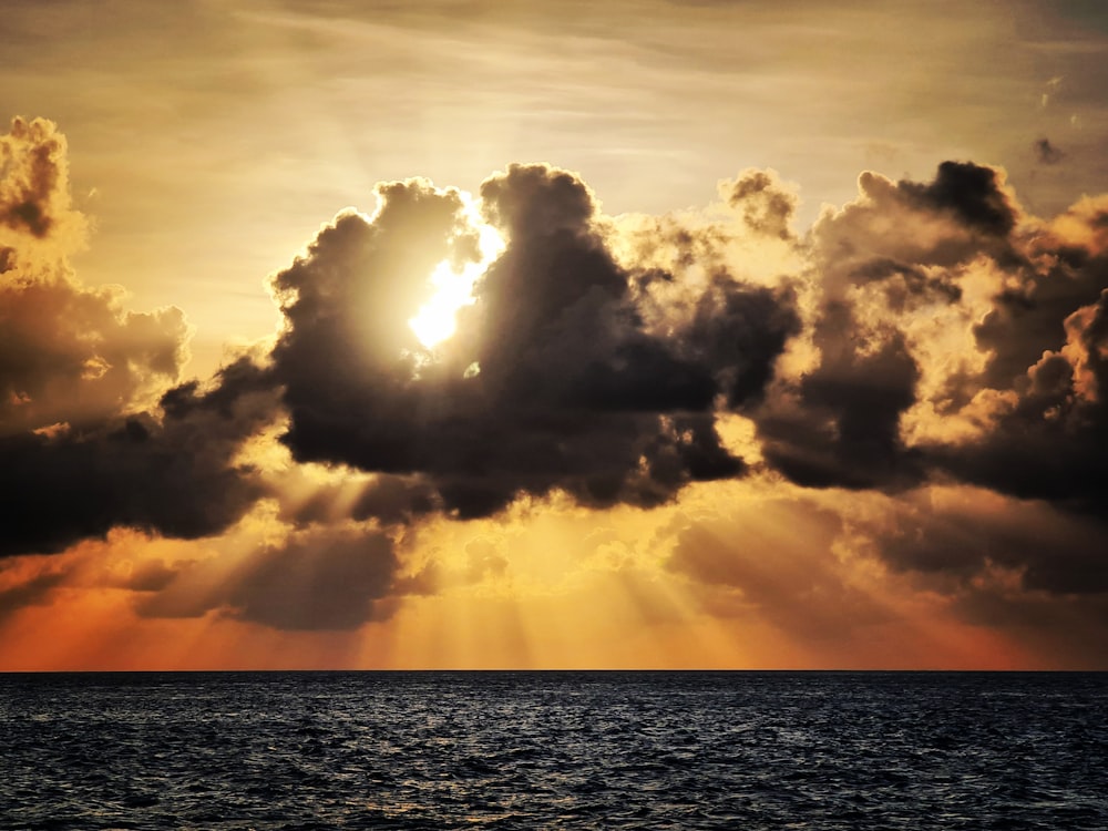 El sol brilla a través de las nubes sobre el océano