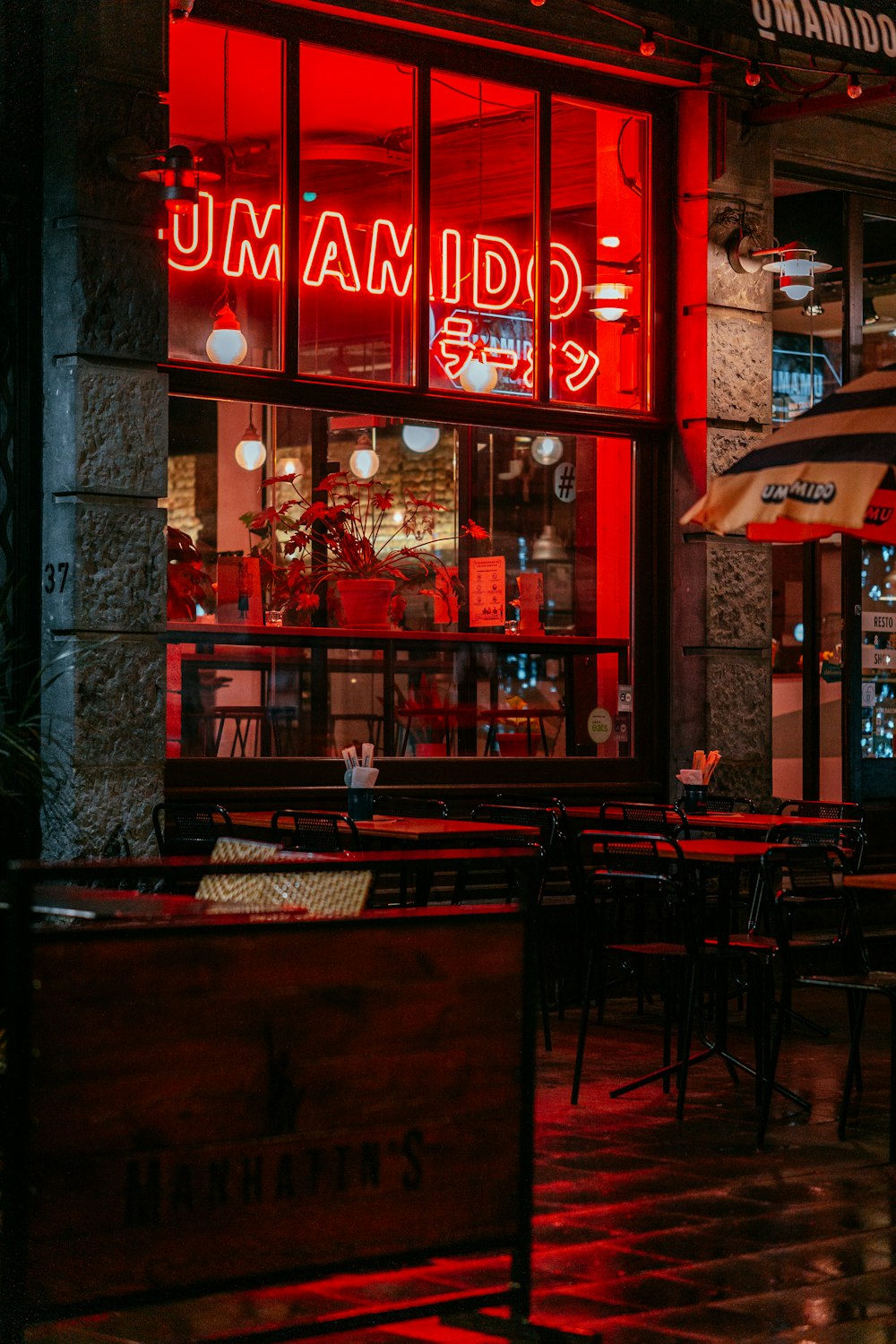 a restaurant with a red neon sign in the window