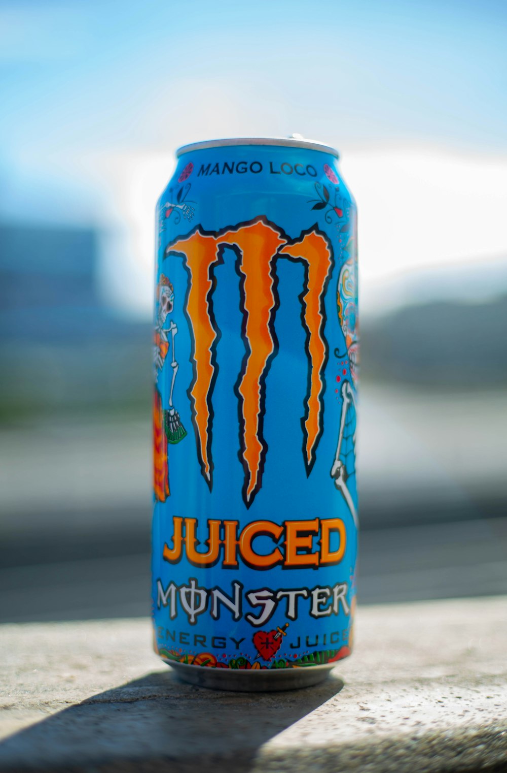 a can of monster juice sitting on the ground