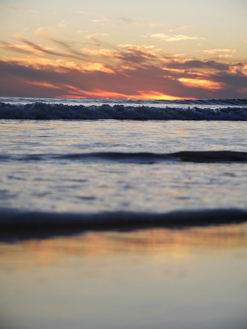 the sun is setting over the ocean waves