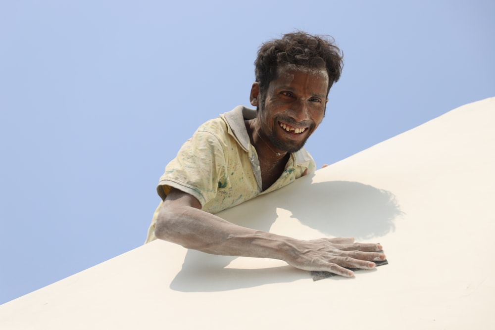 a man laying on top of a white wall
