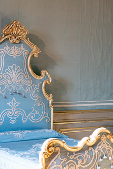 Elegant temple-inspired pet bed in deep navy with gold accents, set against a soft cream background.