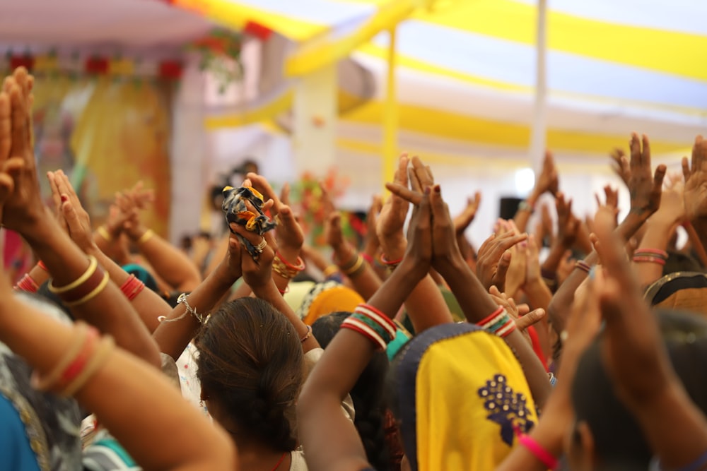 a crowd of people with their hands in the air