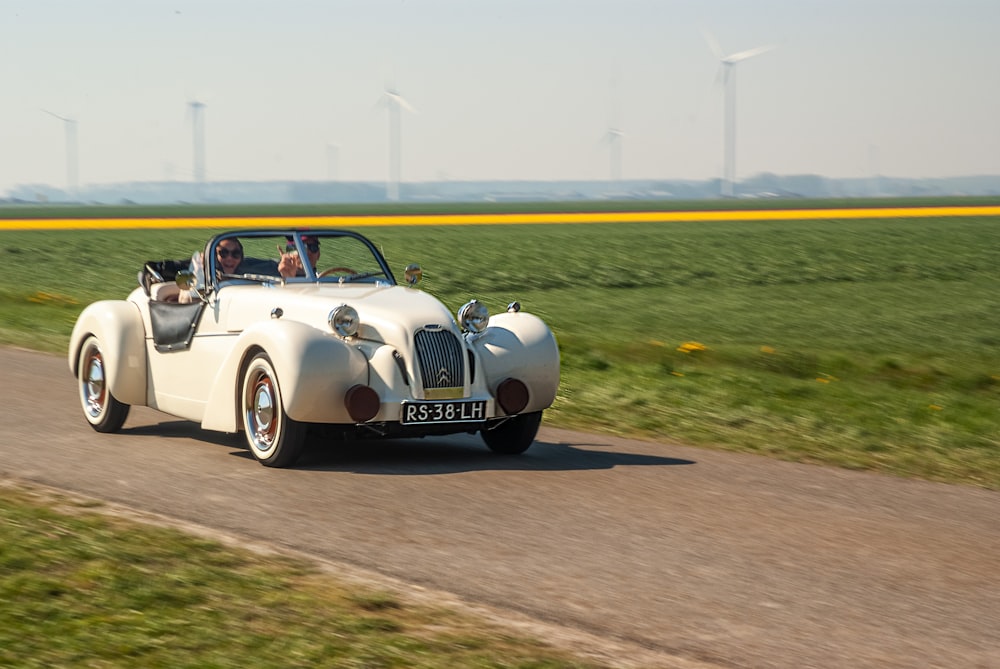 a white car driving down a country road