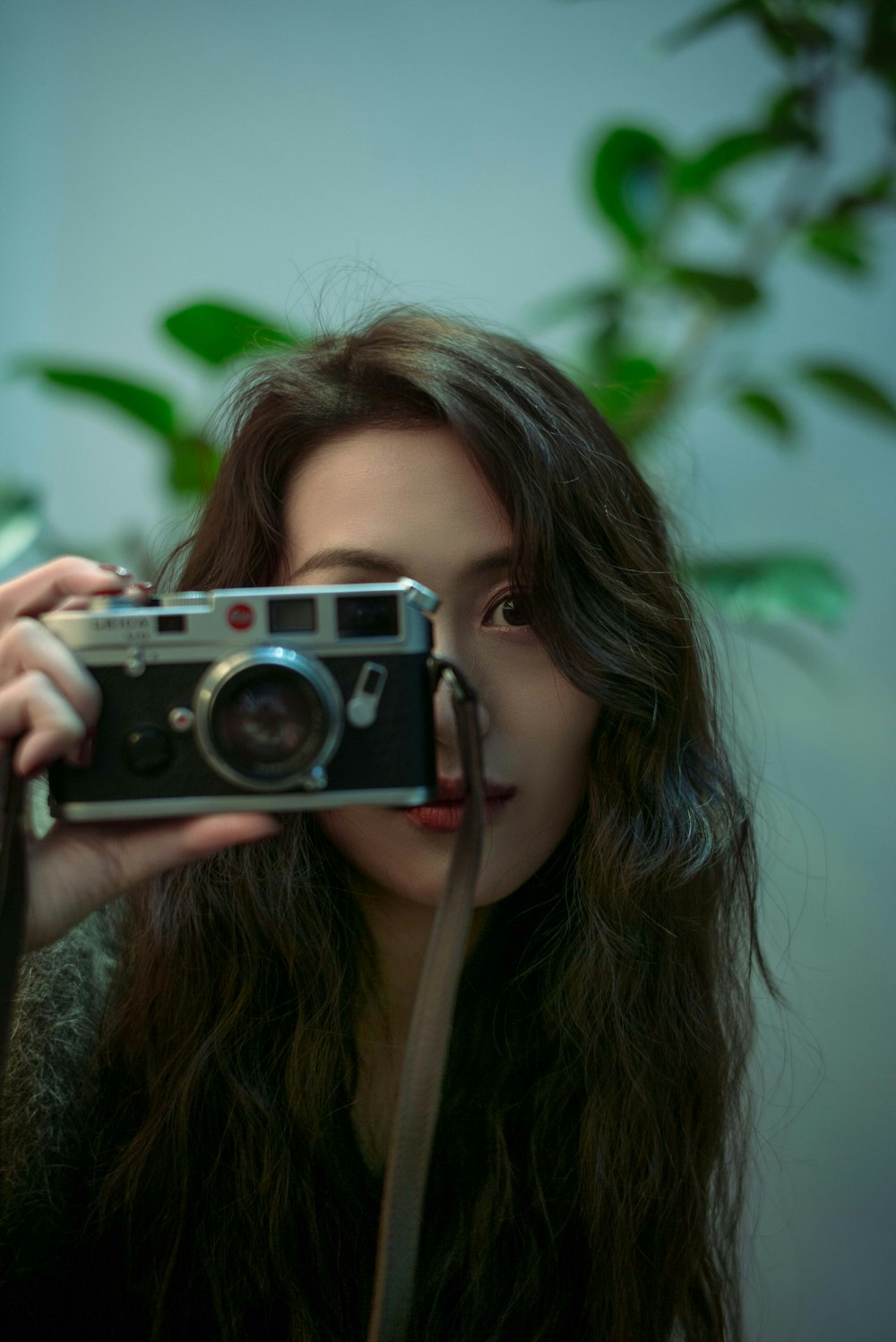 a woman holding a camera up to her face