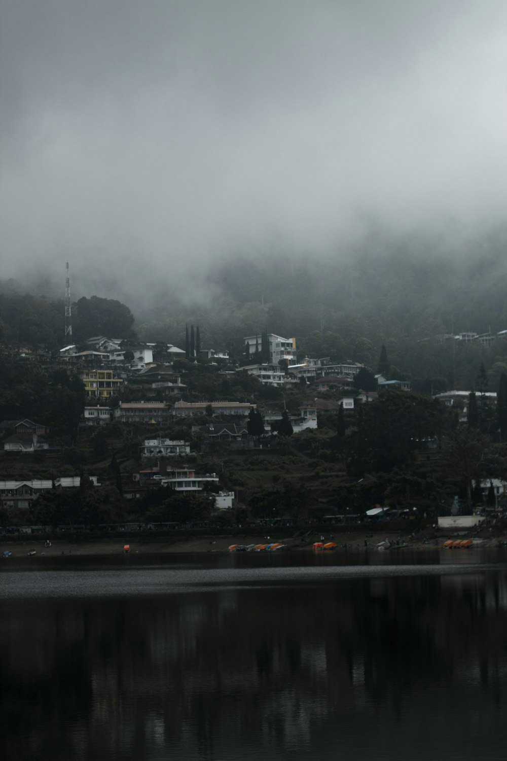 a city on a hill covered in fog