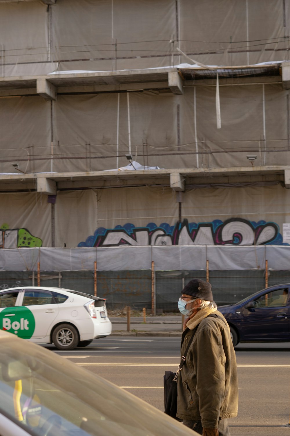 a man wearing a face mask standing in a parking lot