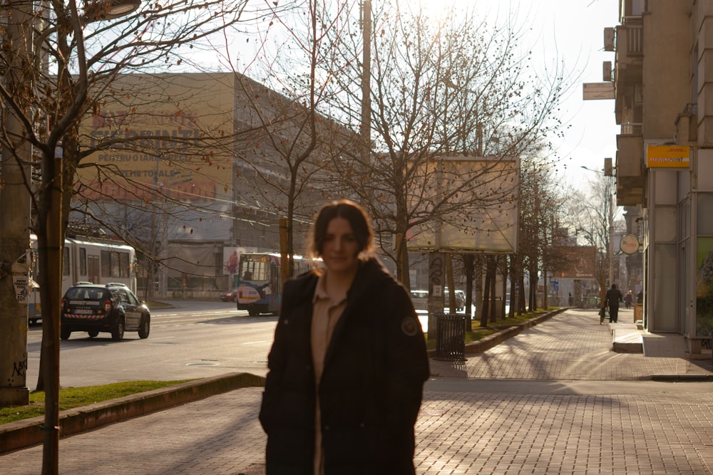 a woman walking down a street next to trees