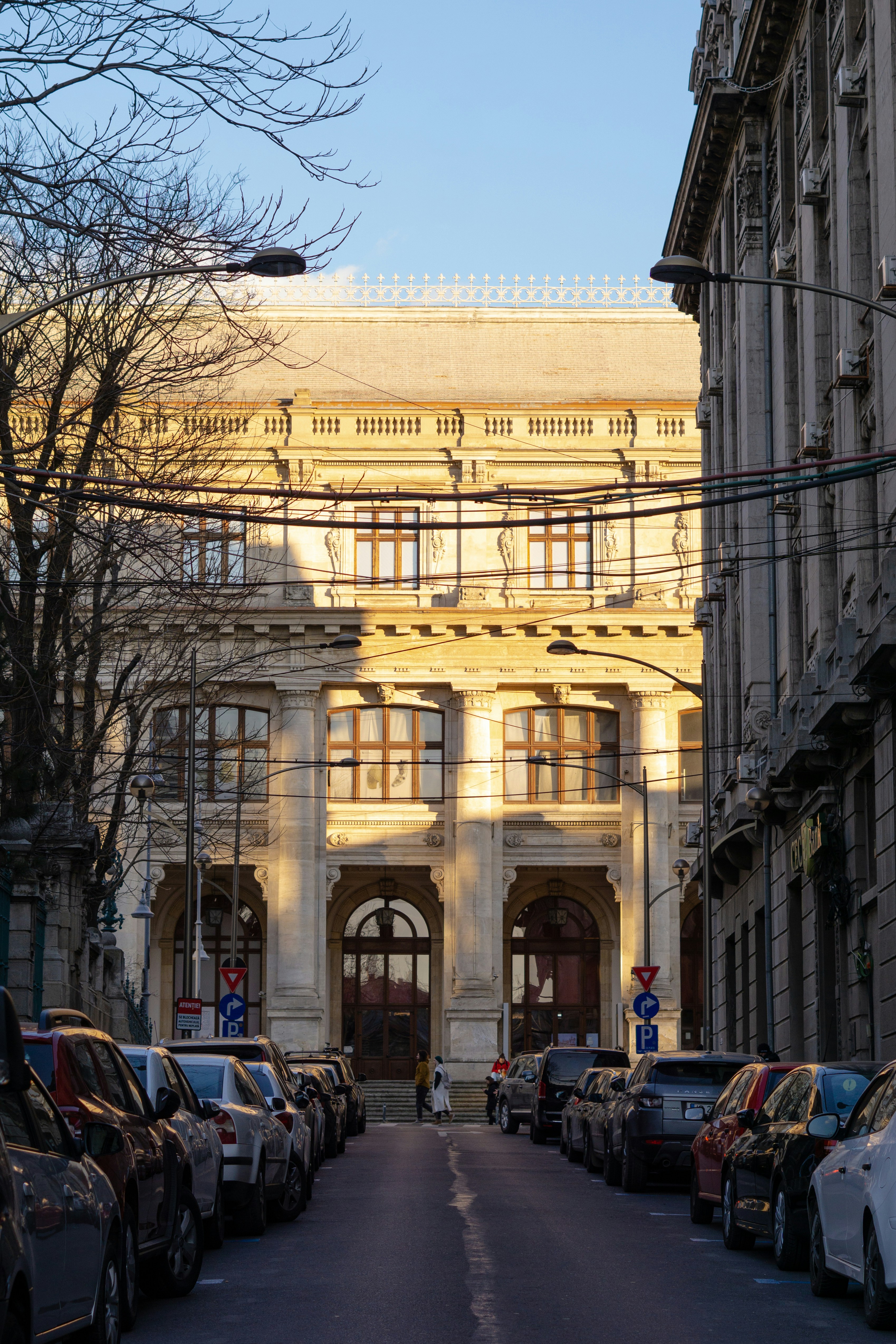 a street lined with parked cars next to tall buildings