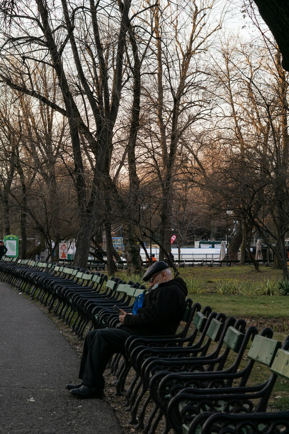 a man sitting on a bench in a park