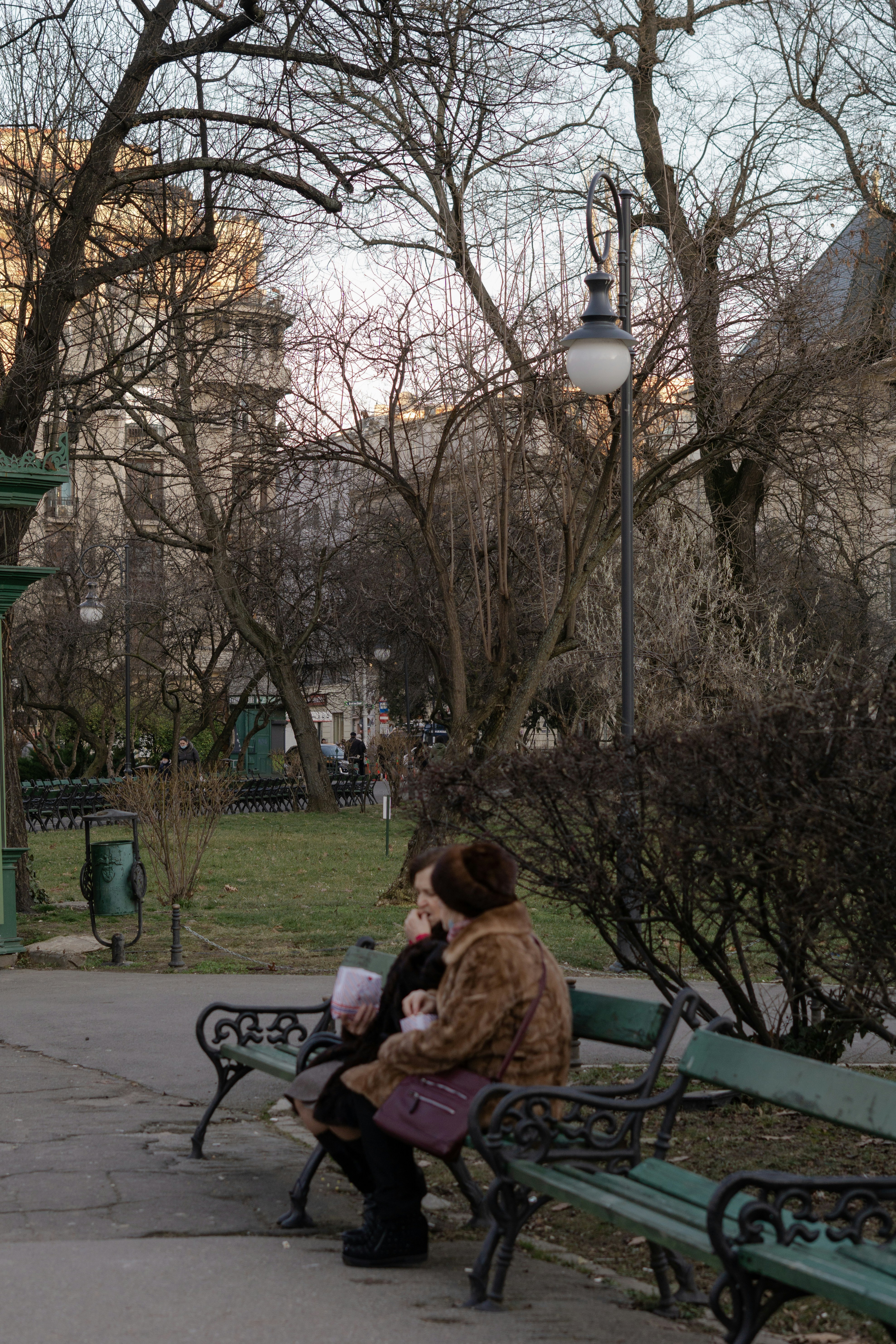 a woman sitting on a bench in a park