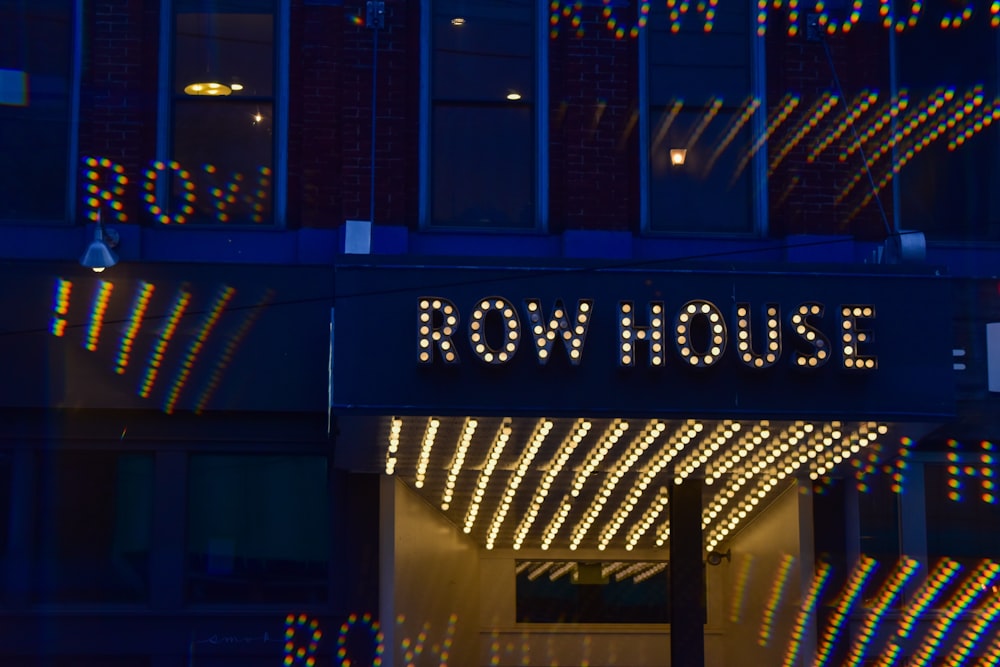 a building with a row house sign lit up at night