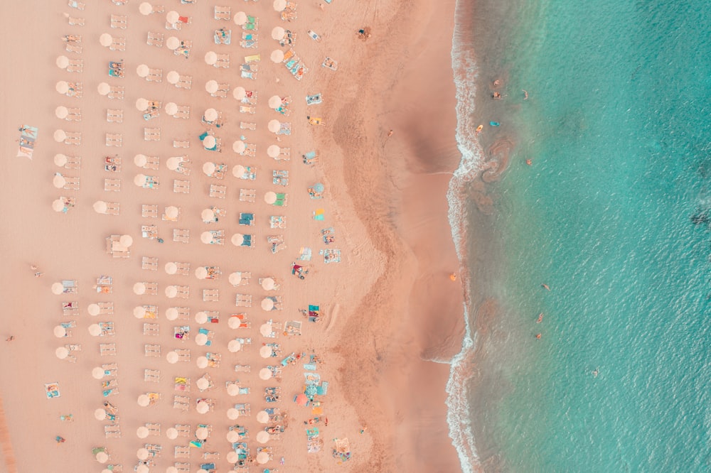 an aerial view of a beach with umbrellas and chairs