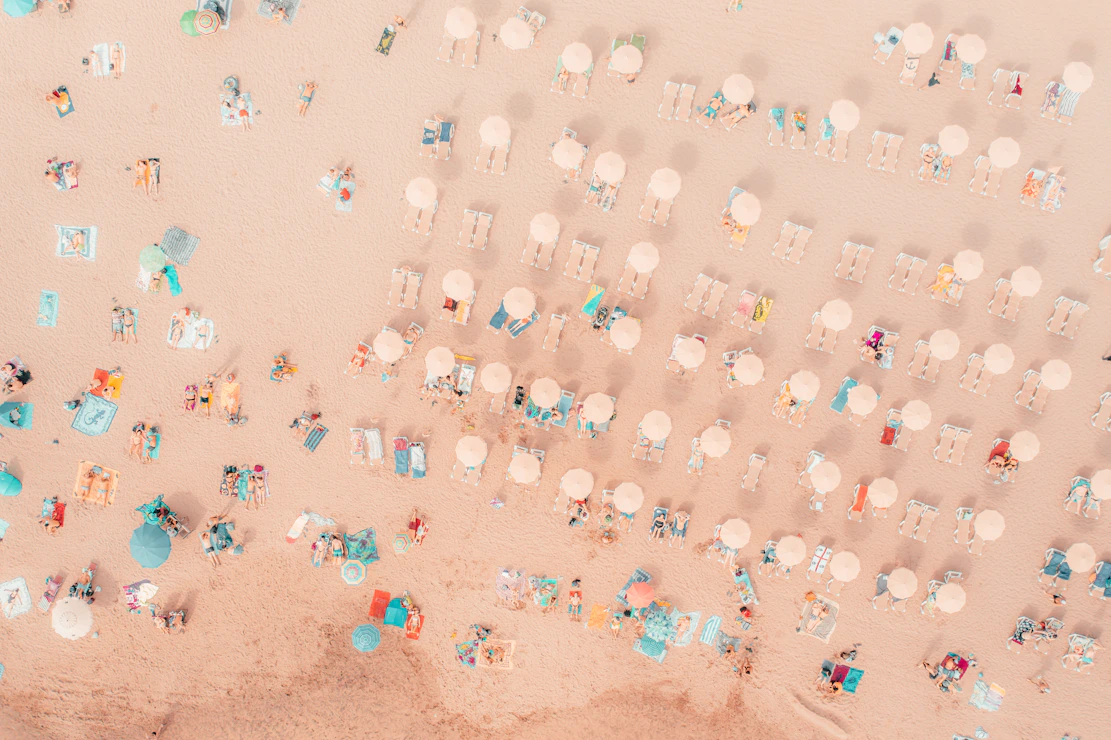 an aerial view of a beach with umbrellas and chairs