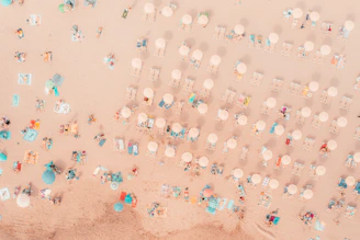 an aerial view of a beach with umbrellas and chairs