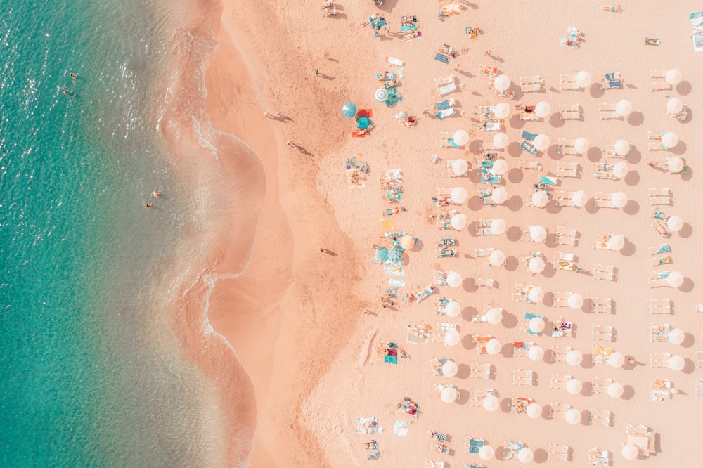 an aerial view of a beach with umbrellas and chairs