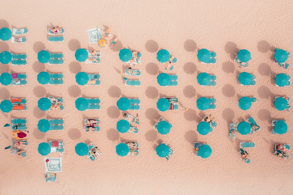 an overhead view of a sandy beach with chairs and umbrellas
