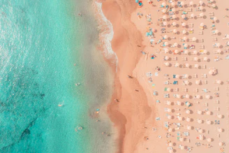 an aerial view of a beach with umbrellas and chairs