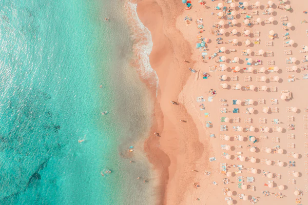 Strand mit Sonnenschirmen und Liegen aus der Vogelperspektive
