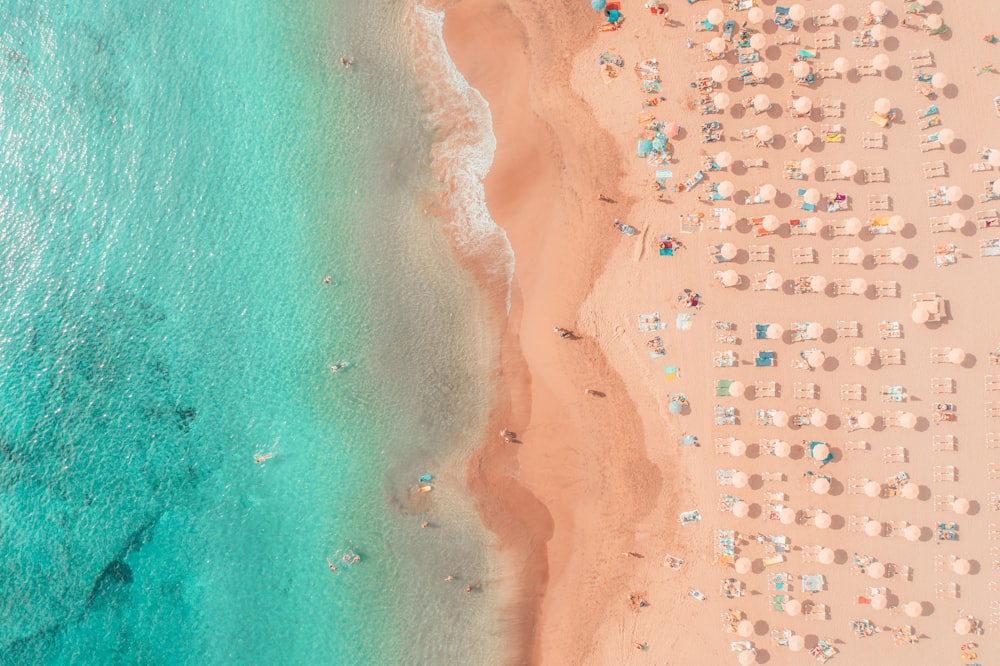 an aerial view of a beach with umbrellas and chairs