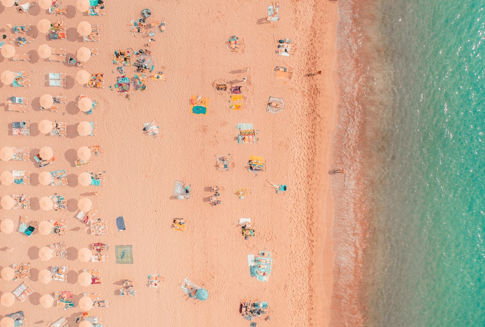 an aerial view of a beach with chairs and umbrellas