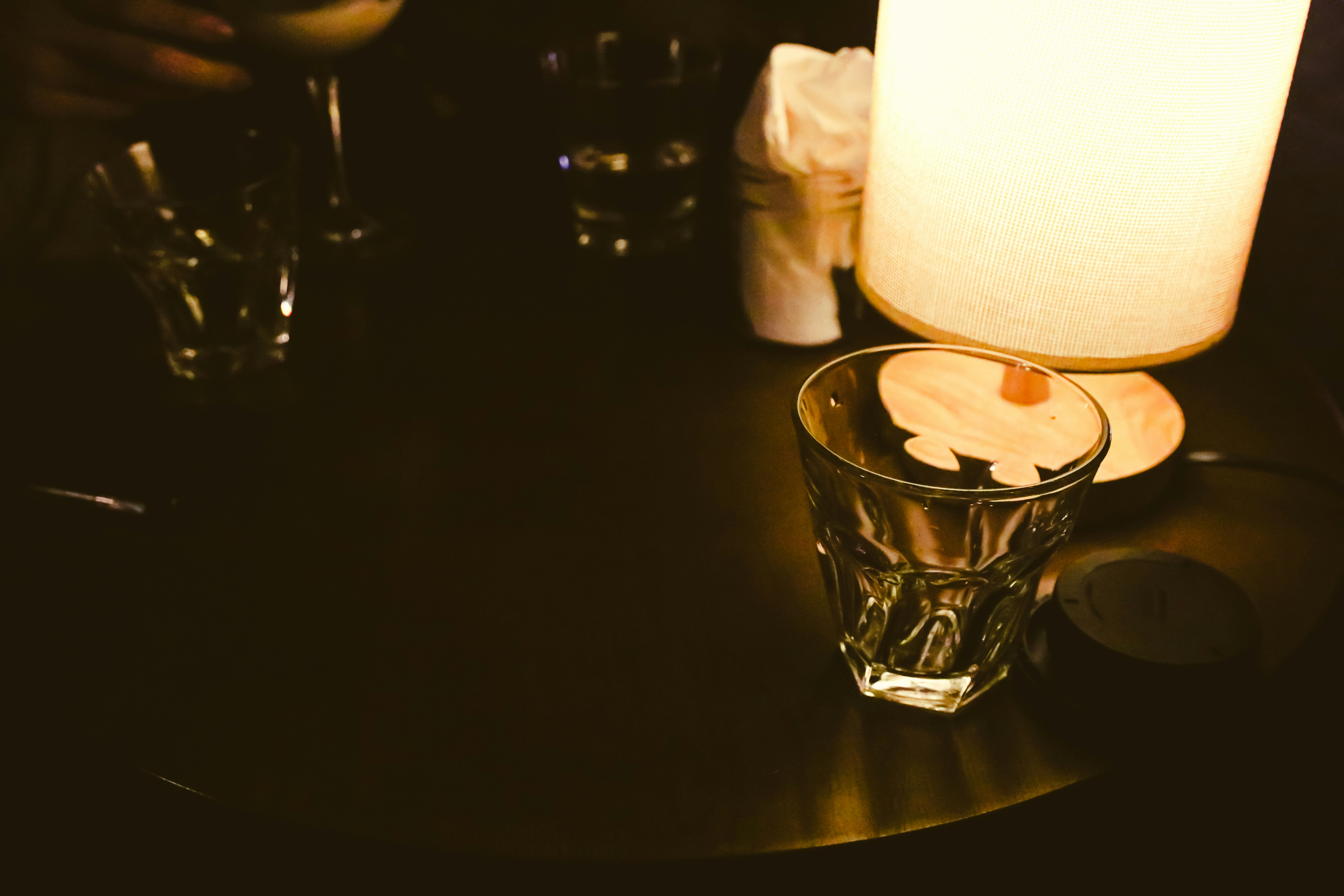 Glass and lamp on a dark bar table