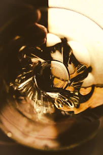 Close-up of handcrafted resin-based goods with gentle swirls of pink and gold, glowing softly under warm light.